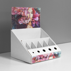 Cardboard counter display with inserts and slots for makeup products and a header - printed